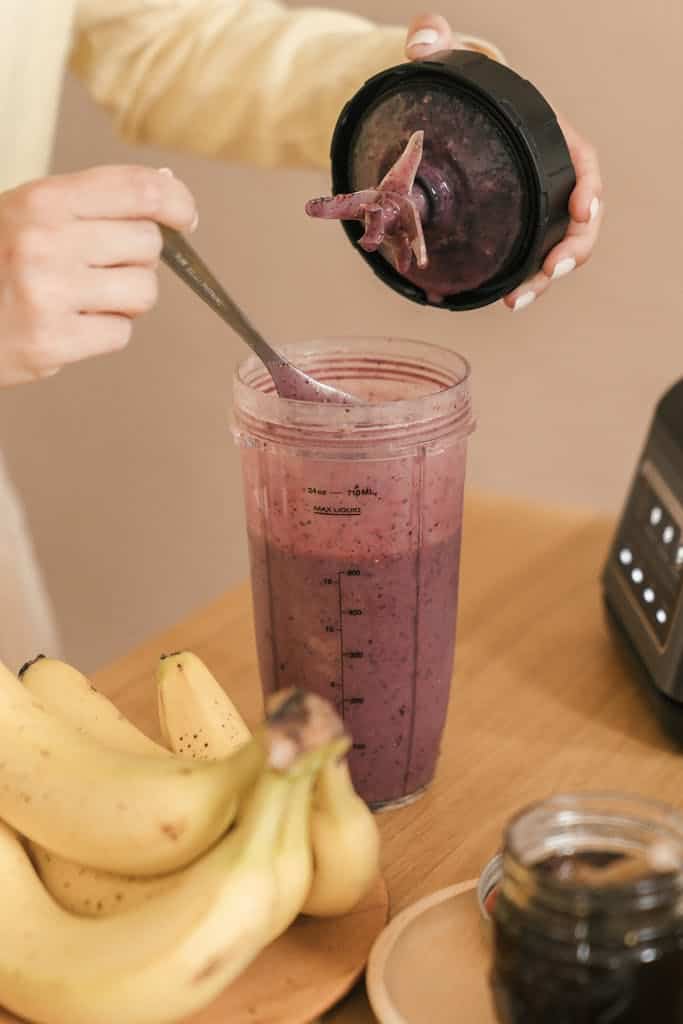 Close-up of a homemade smoothie preparation with bananas and mixed berries.