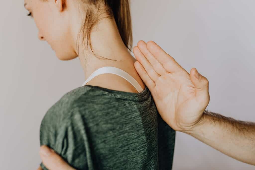 A professional chiropractor assisting a patient with spine alignment therapy to fix neck hump.