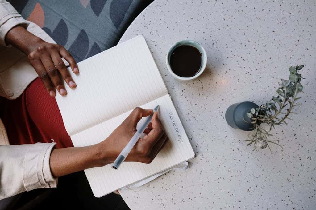 massage therapist writing in a planner to set boundaries and take breaks to extend massage therapy career and focusing on planning and productivity.