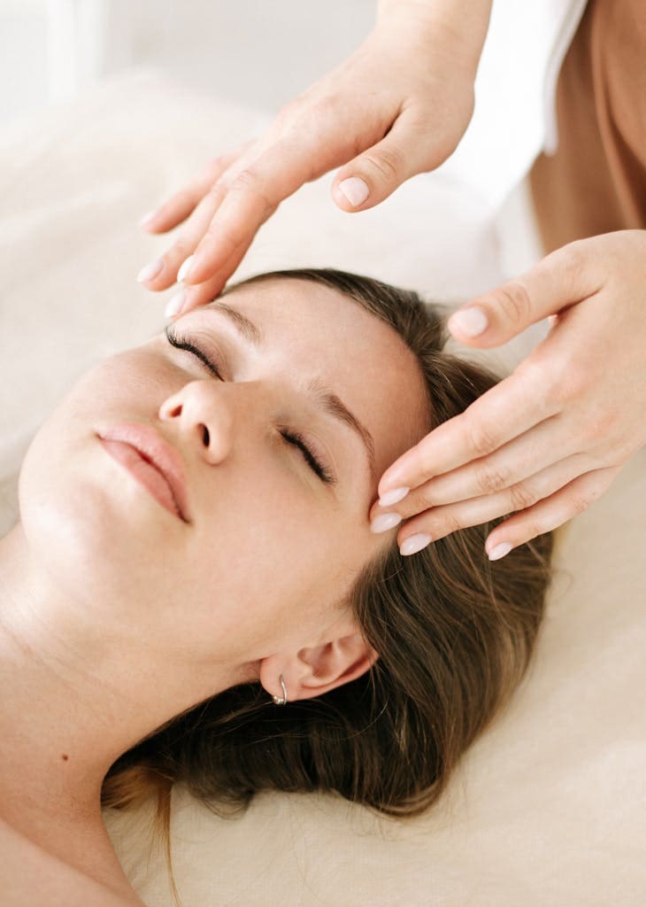 massage therapist receiving a soothing facial massage in a relaxing spa environment for self-care.