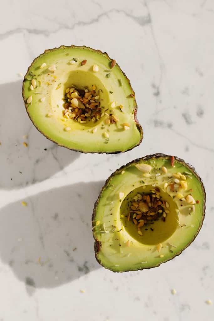 avocado sprinkled with seeds for ehalthy fats to naturally balance hormones